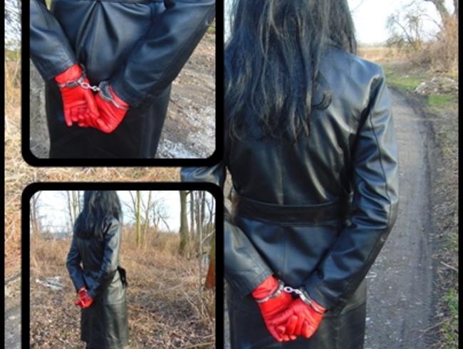 A small walk in a leather coat and with handcuffs