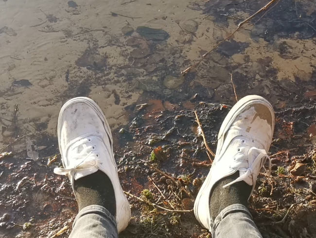 Draußen vorm See mit weißen Schuhen matschen