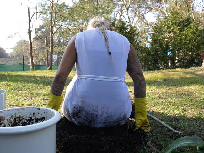 Dreckige Gartenarbeit im noch weißen Kittel aus Dederon und gelben Latex Gummihandschuhen