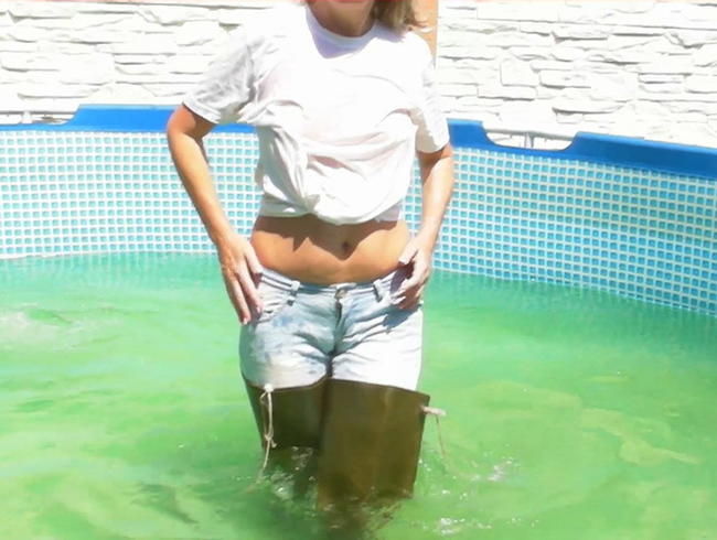 In Waders mit Jeans und nassem T-Shirt im Pool