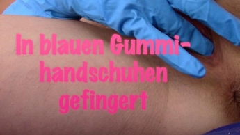 Mit blauen Gummihandschuhen gefingert