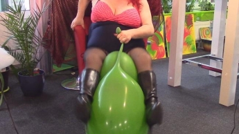 Sitting on green balloon with black boots. NON-POP !