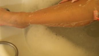 Stiefmutter rasiert sich im Badezimmer die Beine