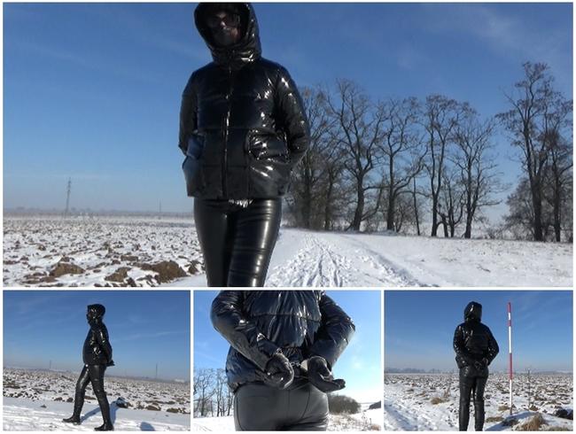 Winterspaziergang in einer PVC-Daunenjacke und Handschellen (Hände zurück)