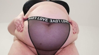 Blick von unten auf den großen, einladenden Bauch einer BBW