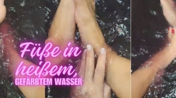 Füße in heißem, gefärbtem Wasser